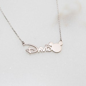 Puede incluir: Collar de plata con una cabeza de Mickey Mouse y el nombre "David" en una fuente de Disney.