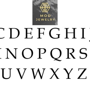 Op de afbeelding: Zwarte en witte alfabetletters A tot en met Z in een eenvoudig, sans-serif lettertype. De letters zijn gerangschikt in drie rijen. Het woord "MOD JEWELRY" staat boven de letters in een gouden, sans-serif lettertype.