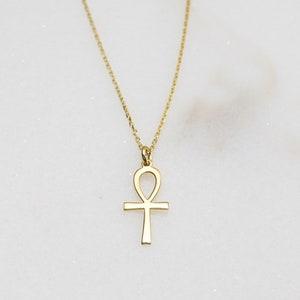 K&ouml;nnte beinhalten: Eine goldene Kettenkette mit einem goldenen Ankh-Anh&auml;nger.