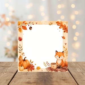Könnte beinhalten: Eine quadratische Karte mit einem Aquarell-Rahmen aus herbstlichen Elementen wie orangefarbenen Kürbissen, roten und orangefarbenen Blättern, einer Eichel und einem kleinen Fuchs, der neben einer Tasse auf einer Strickdecke sitzt, um ein weißes Zentrum.