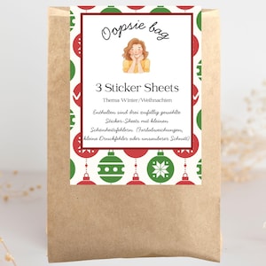 Könnte beinhalten: Ein brauner Papiersack mit einem Etikett mit der Aufschrift "Oopsie bag" und "3 Sticker Sheets". Das Etikett hat ein Muster aus roten und grünen Weihnachtskugeln. Der Text besagt, dass die Aufkleber kleine Fehler aufweisen.