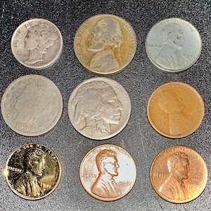 Puede incluir: Nueve monedas antiguas de EE. UU., incluyendo dimes de plata, níqueles y peniques, están dispuestas sobre una superficie oscura. Las monedas muestran varias fechas y diseños, como el dime Mercury y el níquel Buffalo. Las monedas están en diversas condiciones.