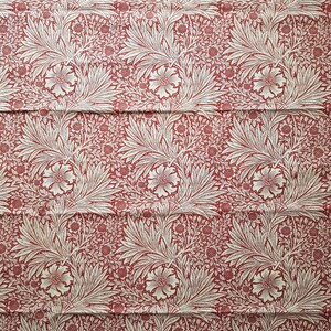 Könnte beinhalten: Ein sich wiederholendes Muster aus stilisierten Blumen und Blättern in Creme und Rot. Das Design zeigt große, offene Blüten, breite Blätter und kleinere florale und Beeren-Elemente, die eine dichte, verzierte Komposition bilden. Der Stoff hat eine Vintage-Ästhetik.