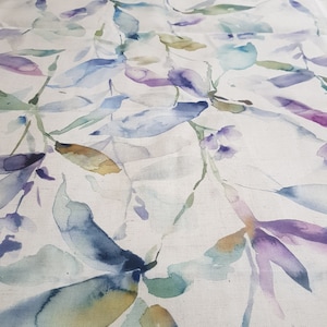 Może przedstawiać: Tkanina akwarelowa z białym tłem i wzorem niebieskich, zielonych i fioletowych liści. Liście są namalowane w luźnym, abstrakcyjnym stylu.