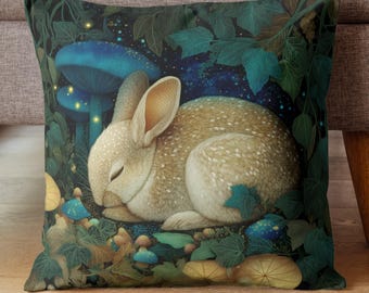 May include: Square decorative pillow featuring a sleeping rabbit with speckled fur, nestled among blue mushrooms and lush green foliage. The design has a whimsical, fairytale theme with a starry night sky background.