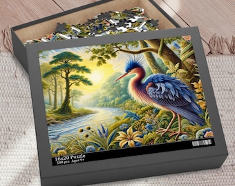May include: A 500 piece jigsaw puzzle featuring a blue heron standing in a lush green forest by a river. The puzzle is in a black box with the text "16x20 Puzzle 500 pcs Ages 9+" on the front.