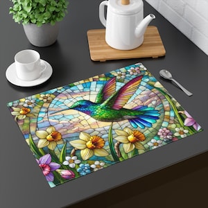 May include: A colorful stained glass style hummingbird with iridescent wings and a long beak, flying over a field of daffodils and other flowers. The background is a mosaic of blue, green, and yellow.