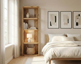 May include: A wooden bookcase with four shelves, displaying books, a lamp, a vase, and a woven basket. The room includes a bed with white bedding, abstract art, and a window with sheer curtains. The style is minimalist and modern.