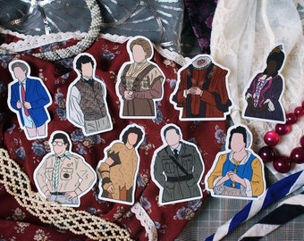 May include: Set of ten illustrated stickers featuring various characters in different historical costumes. The stickers are printed on white paper and have a glossy finish.