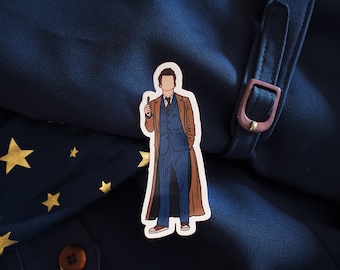 May include: A sticker of a cartoon character wearing a brown coat and a blue suit. The character is holding a device in their right hand and has their left hand in their pocket.