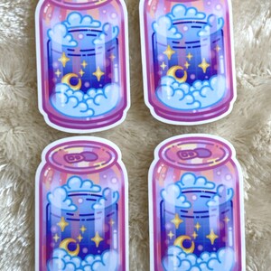 May include: Four stickers of a pink and purple can with a blue liquid inside. The liquid has a crescent moon, stars, and clouds inside. The can has a white outline.