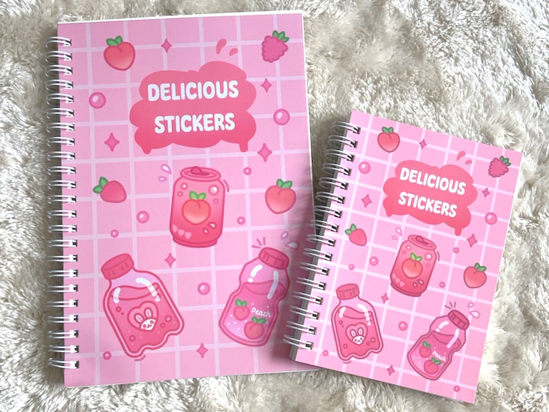 May include: Two pink spiral bound notebooks with a grid pattern and peach, strawberry, and raspberry illustrations. The notebooks have the text "Delicious Stickers" on the front.