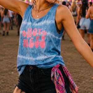 May include: A blue tie-dye vest top featuring the pink glitter text HOT MESS on the front, paired with black denim shorts that have a frayed hem and a colourful patterned bandana tied to the side belt loop of the shorts.