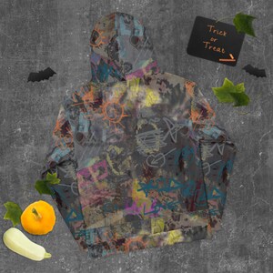 May include: A gray hoodie with a colorful graffiti print. The print features various shapes, lines, and words, including "Love" and "Trick or Treat".