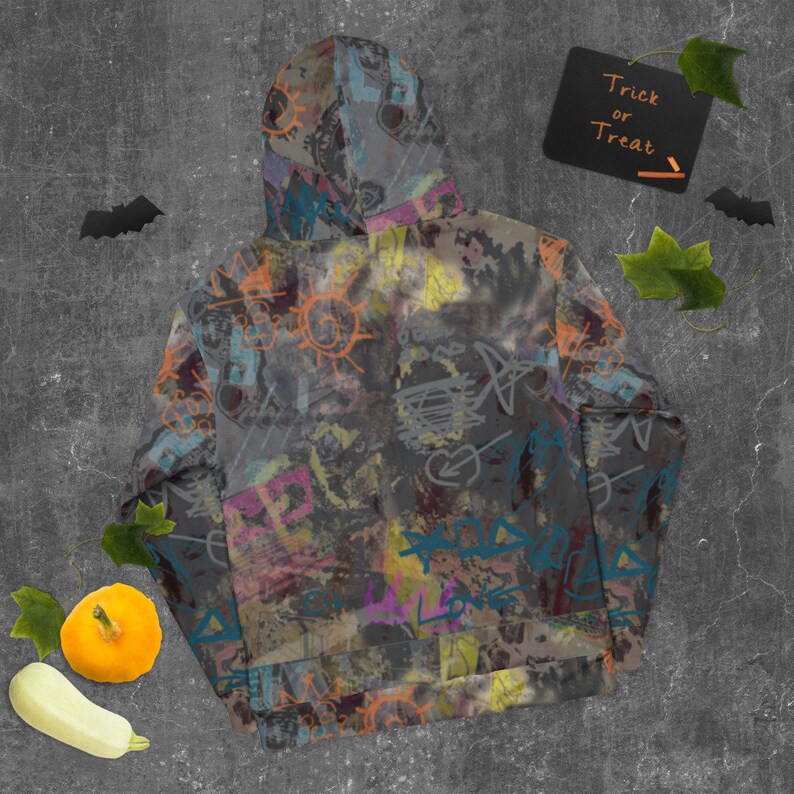 May include: A gray hoodie with a colorful graffiti print. The print features various shapes, lines, and words, including "Love" and "Trick or Treat".