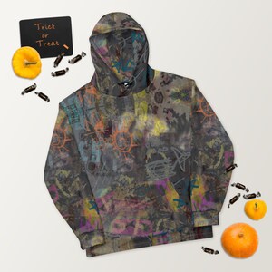 May include: A gray hoodie with a colorful abstract print. The print features a variety of shapes, lines, and colors, including orange, yellow, blue, and green. The hoodie has a drawstring hood and a kangaroo pocket.