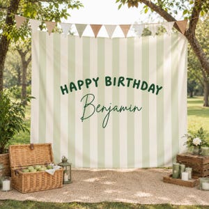 May include: A birthday party scene with a striped backdrop reading "HAPPY BIRTHDAY Benjamin". A picnic setup includes a wicker basket, candles, and a banner of triangular flags. The scene is set outdoors.