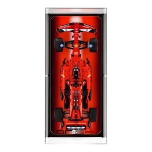 May include: A red Lego Ferrari Formula 1 race car model displayed in a clear acrylic display case. The car has the text "SF-24" on the bottom.