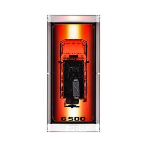 May include: A toy truck model in orange and black, viewed from above, is encased in a clear rectangular display. The background is a gradient of red and orange. The text "G 500" and "200" are printed at the bottom of the case.