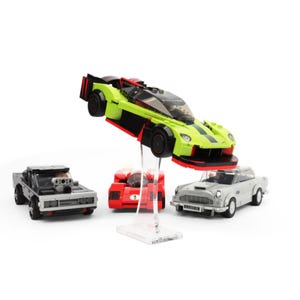 May include: A green, black and red Lego car model with a black and silver Lego car model, a red Lego car model and a silver Lego car model.