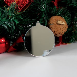 May include: A silver mirrored Christmas bauble with a loop at the top for hanging.