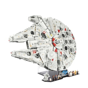 May include: A detailed LEGO Millennium Falcon model with a white and grey colour scheme, red accents, and a black display stand. The model includes several minifigures, including Han Solo, Chewbacca, Princess Leia, and Luke Skywalker.