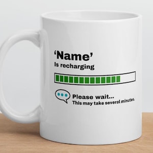 May include: White ceramic mug with a black and green progress bar graphic that reads 'Name' is recharging. The progress bar is almost full. Below the progress bar is a speech bubble with the text 'Please wait... This may take several minutes.'