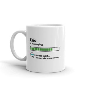 May include: White ceramic mug with a black and green graphic that says "Eric is recharging" with a progress bar and the text "Please wait... This may take several minutes."