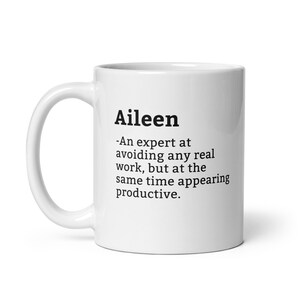 May include: White ceramic coffee mug with a black text design that reads "Aileen - An expert at avoiding any real work, but at the same time appearing productive."