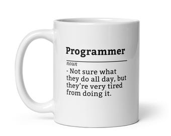 Peut inclure: Mug en céramique blanche avec le mot "Programmer" en noir et une définition humoristique. Le texte dit : "Pas sûr de ce qu'ils font toute la journée, mais ils sont très fatigués de le faire."