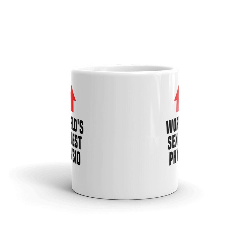 K&ouml;nnte beinhalten: Wei&szlig;e Keramik-Kaffeetasse mit schwarzem Text, der "World's Sexiest Physio" lautet, mit einem roten Pfeil, der auf jeder Seite des Textes nach oben zeigt.