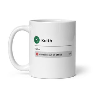 May include: White ceramic mug with a handle. The mug features a graphic that mimics a status update, displaying "Keith" with a green circle and the status "Mentally out of office."