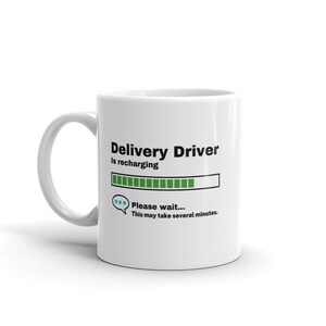 Könnte beinhalten: Eine weiße Keramiktasse mit einer schwarzen und grünen Grafik, auf der "Delivery Driver is recharging" steht, mit einer Fortschrittsanzeige und einer Sprechblase, auf der "Bitte warten... Dies kann einige Minuten dauern." steht.