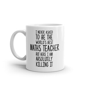 May include: White ceramic coffee mug with black text that reads "I never asked to be the world's best maths teacher but here I am absolutely killing it."