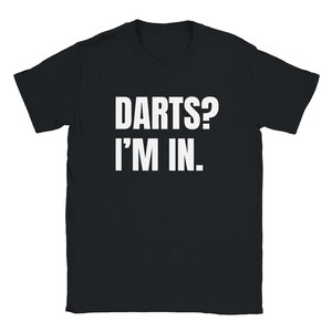 May include: Black t-shirt with the white text "DARTS? I'M IN." The shirt has a crew neck and short sleeves. The text is centered on the front of the shirt.
