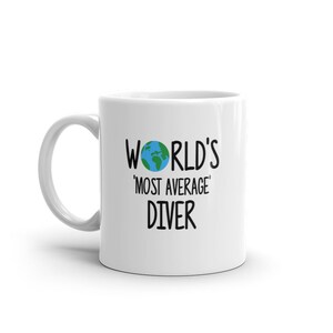 May include: White ceramic mug with a black graphic that says "World's 'Most Average' Diver" with a small blue and green globe graphic above the text.