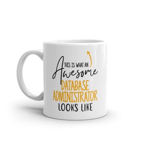Könnte beinhalten: Weiße Keramik-Kaffeetasse mit einem schwarzen und goldenen Design. Der Text auf der Tasse lautet "So sieht ein großartiger Datenbankadministrator aus".