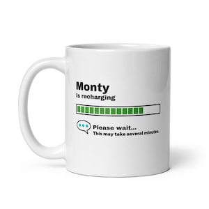 May include: White ceramic coffee mug with a black graphic that says "Monty is recharging" with a green progress bar and the text "Please wait... This may take several minutes."