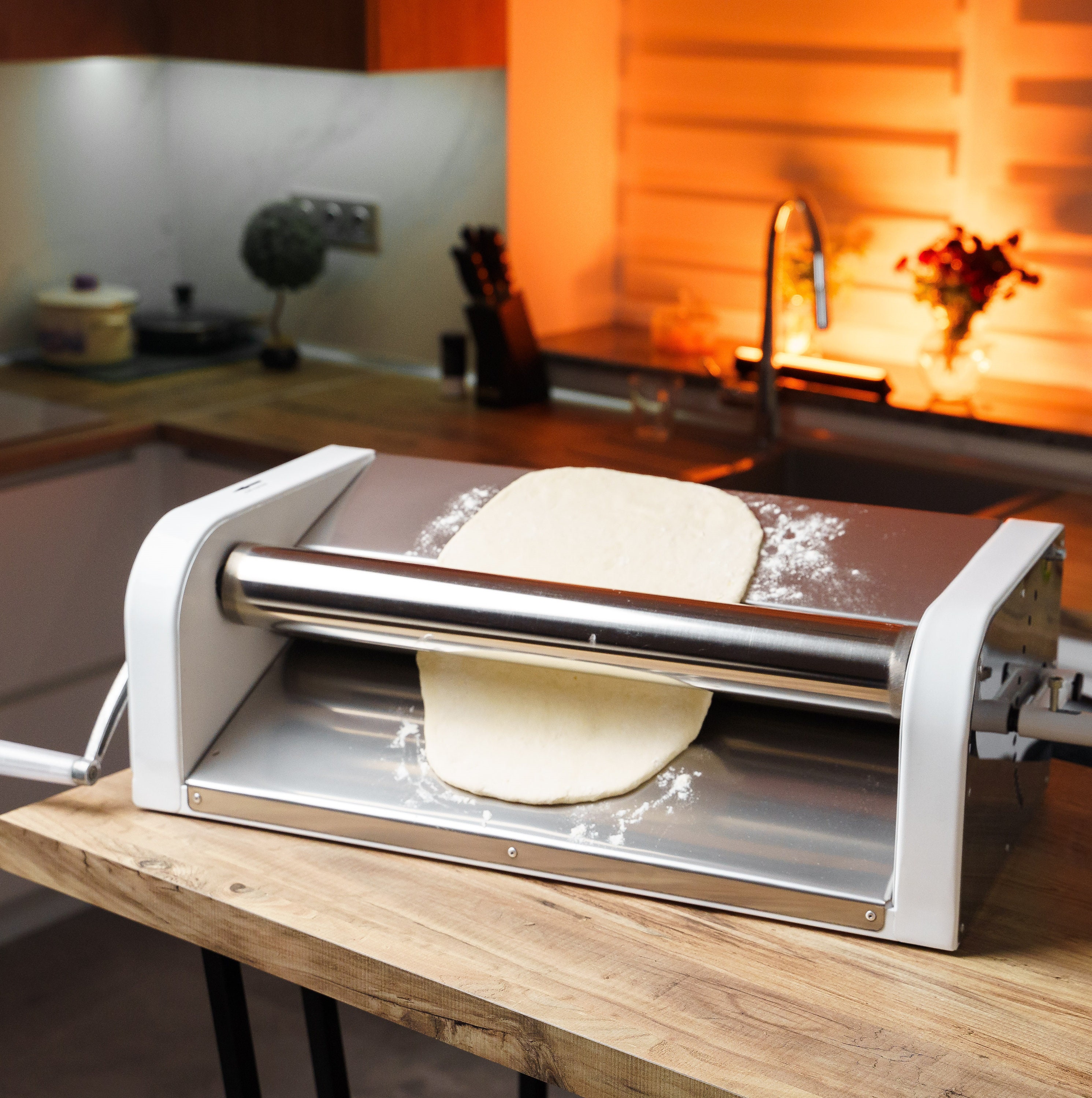 Chef rodando la masa con una máquina de pasta. máquina para hacer