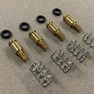 May include: Four gold-colored metal push buttons with springs. Each button has a black rubber o-ring.