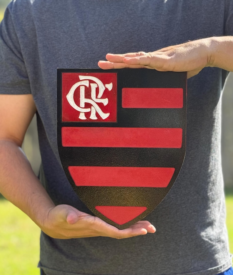 Peut inclure: Un panneau en forme de bouclier noir et rouge avec un logo "CR" blanc dans la partie sup&eacute;rieure et des rayures horizontales rouges et noires dans la partie inf&eacute;rieure.