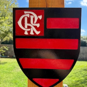 Peut inclure: Un panneau en forme de bouclier noir et rouge avec un monogramme blanc "CR" dans le coin sup&eacute;rieur gauche. Le bouclier comporte cinq bandes horizontales rouges sur fond noir.