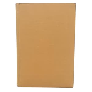 May include: A hardcover book with a plain, light brown cover. The book's spine is visible on the left side, and the cover has a slightly textured appearance. The edges of the book are worn, suggesting it is vintage.
