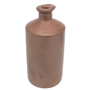 May include: A brown stoneware bottle with a rounded body and a narrow neck with a spout. The bottle has a smooth, matte finish and a slightly aged appearance. The bottle is likely an antique or vintage item.