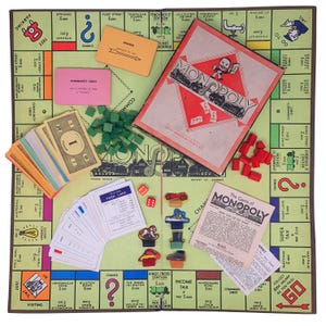 May include: A vintage Monopoly board game set, featuring a green game board with property spaces, Chance and Community Chest cards, play money, dice, and red and green game pieces. The Monopoly box is open, revealing the game's title.