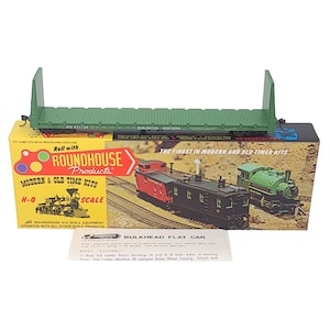 May include: A green bulkhead flat car model kit with the text "BURLINGTON NORTHERN" and "ROUNDHOUSE Products" on the box. The kit includes trucks and couplers. The box features images of model trains.