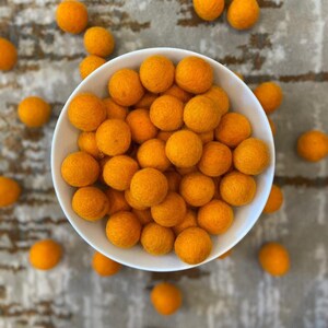 Selección roja y naranja (swipe) de pompones de fieltro de lana 100% nepalí de 2,5 cm