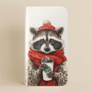 May include: A white phone case featuring a watercolor illustration of a raccoon wearing a red hat and scarf, holding a coffee cup. The raccoon has a black mask and is set against a neutral background.