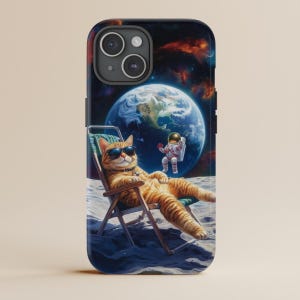 May include: A phone case with a cartoon image of a cat wearing sunglasses and relaxing on a beach chair on the moon. An astronaut is floating in the background. The Earth is visible in the distance.
