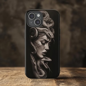 May include: Black phone case featuring a graphic of a woman with snakes for hair. The woman is looking down with a sad expression. The snakes are wrapped around her head and neck.